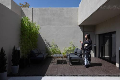 a woman standing on a patio with a kite at Koum Ryokan Hotel Gijang by Aank in Busan
