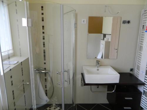 y baño con lavabo y ducha. en LUX Apartman, en Balatonfüred