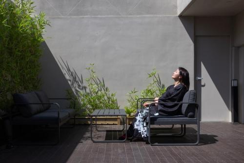 a woman sitting in a chair in a room at Koum Ryokan Hotel Gijang by Aank in Busan