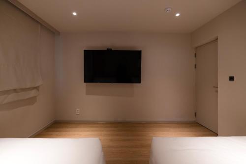 an empty room with a television on the wall at Koum Ryokan Hotel Gijang by Aank in Busan