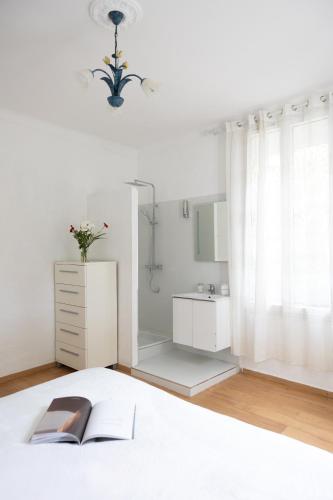 - une chambre avec un lit, un livre et un miroir dans l'établissement Villa Belvedere, à Nice