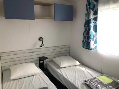 a room with two beds and a window at Camping 3 étoiles - Piscine - ccaihff in Saint-Georges-de-Didonne