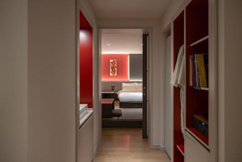 a hallway leading to a bedroom with a bed in it at Koum Ryokan Hotel Gijang by Aank in Busan