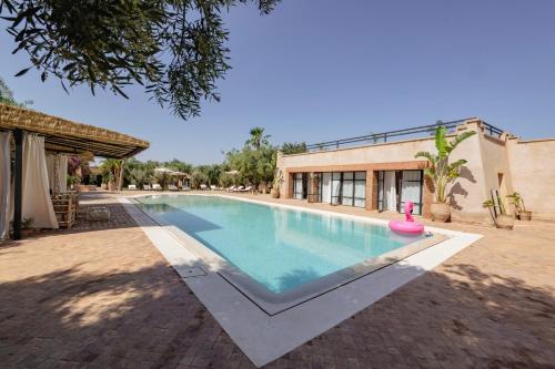 a swimming pool in front of a building at Le mas de l'Ourika, maison d'hôtes in Aït Zat