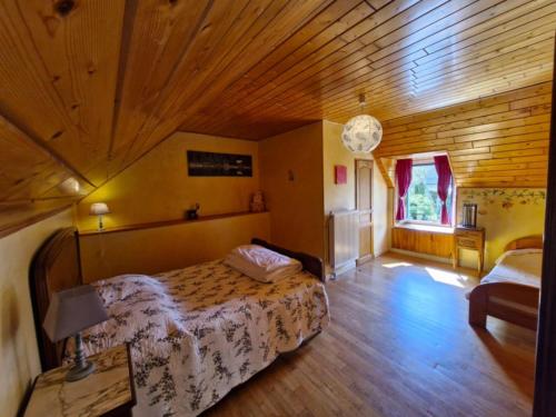 a bedroom with a bed and a wooden ceiling at Maison La Flambée in Bordères-Louron