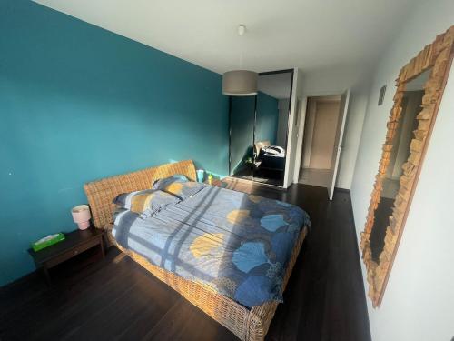 une chambre avec un lit et un mur bleu dans l'établissement Large 2-room bright sea view near airport, à Nice