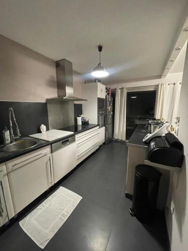 une cuisine avec des armoires blanches et un évier dans l'établissement Large 2-room bright sea view near airport, à Nice