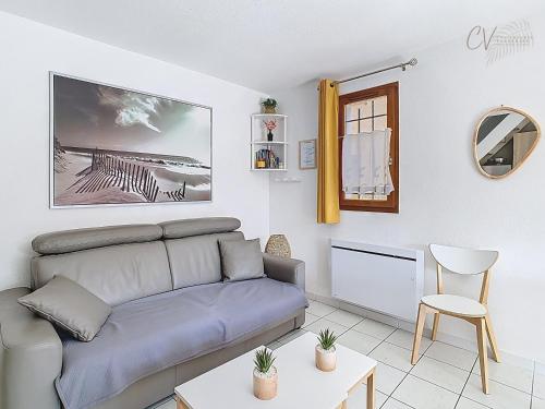 un salon avec un canapé et une table dans l'établissement Petit coin de paradis dans résidence avec piscine, à Vias