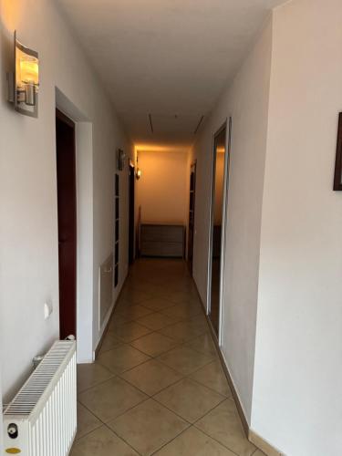 a hallway of a building with a tile floor at Pensjonat E&M in Mikołajki