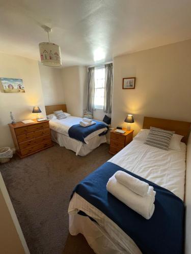 a bedroom with two beds and two lamps and a window at No 3 Mill Cote Cottage in Kingsbridge