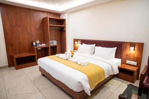 a bedroom with a large bed with towels on it at Hotel The Pearl Shine in Gokarna