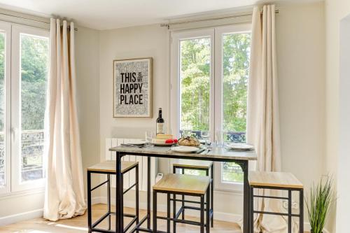 une salle à manger avec une table, des chaises et des fenêtres dans l'établissement Bluestay 23 - Superb studio in Paris, à Paris