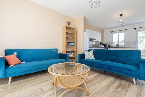 un salon avec un canapé bleu et une table dans l'établissement Appartement de vacances avec terrasse et petit jardin, à Parentis-en-Born