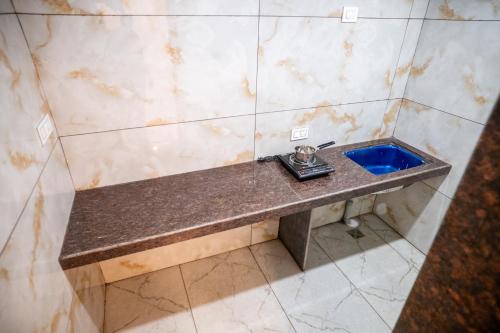 a bathroom with a sink in a tiled wall at Hotel The Pearl Shine in Gokarna