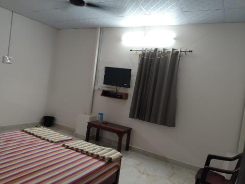 a bedroom with a bed and a television in it at PPR Residency Pollachi in Pollāchi