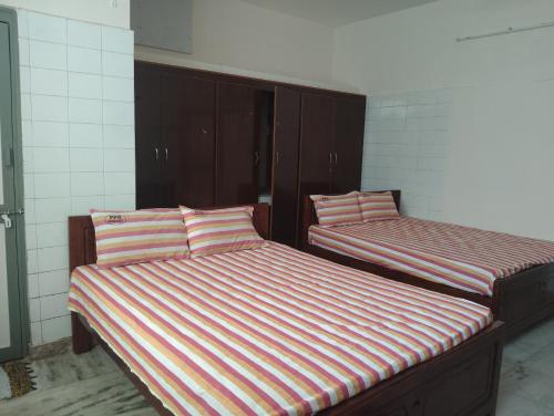 two beds sitting in a room withermottermottermott at PPR Residency Pollachi in Pollāchi