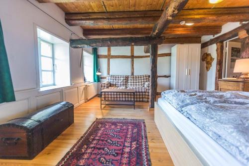 a bedroom with a bed and a chair and a rug at Reetdachhaus mit Elbblick in Lenzerwische