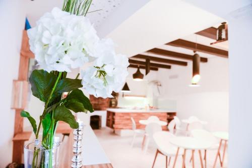 un vase avec des fleurs blanches assises sur une table dans l'établissement Hotel Old Sarajevo, à Sarajevo