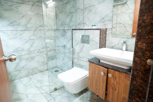 a bathroom with a sink and a toilet and a shower at Hotel The Pearl Shine in Gokarna