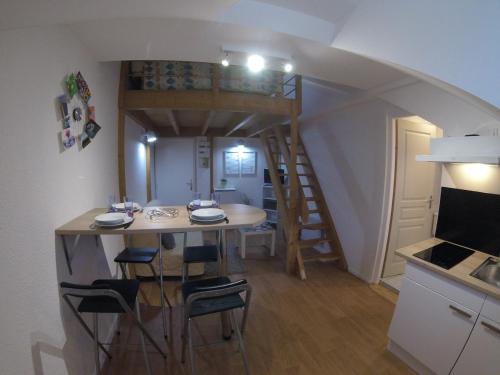 une petite cuisine avec une table et des chaises dans une pièce dans l'établissement Studio mezzanine des Eaux Vives, à Pau