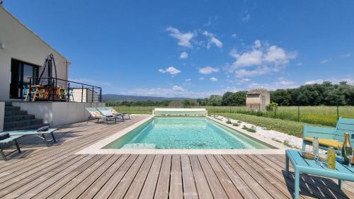 - une piscine sur une terrasse en bois avec des chaises dans l'établissement Lou Miradou, à Maubec