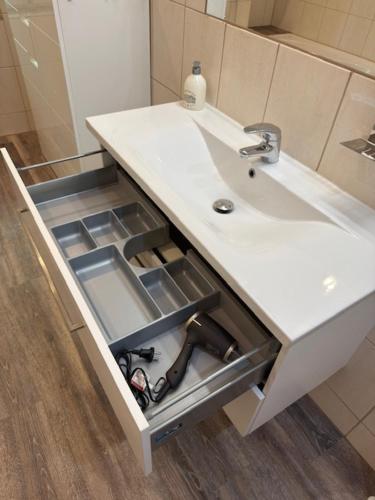 a bathroom sink with an open drawer under it at Am Stadtrand in Chemnitz