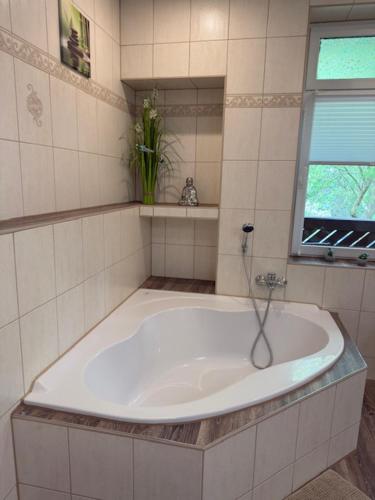 a bath tub in a bathroom with a window at Am Stadtrand in Chemnitz