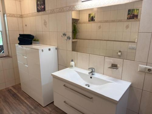 a white bathroom with a sink and a mirror at Am Stadtrand in Chemnitz
