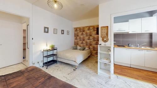 un salon avec un lit et une cuisine dans l'établissement Cosy studio near beaches, à Nice