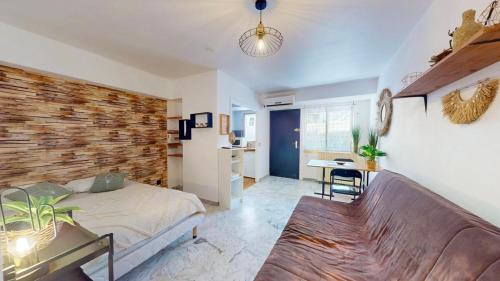 une chambre avec un lit et un mur de briques dans l'établissement Cosy studio near beaches, à Nice