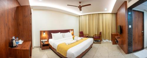a hotel room with a large bed and a desk at Hotel The Pearl Shine in Gokarna