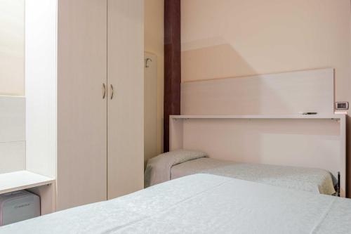 a bedroom with two beds and a closet at Hotel POSTA - 2 stars - Comfortable Stay in Ventimiglia in Ventimiglia