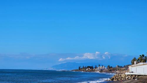 a view of the beach with mountains in the distance at Costa Brisas in Almayate Alto