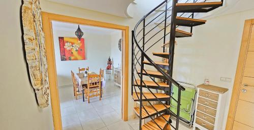 a spiral staircase in a dining room with a table at Costa Brisas in Almayate Alto