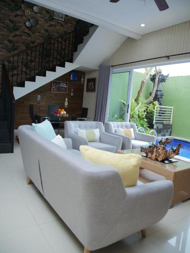a living room with white couches and a table at iVilla in Jimbaran