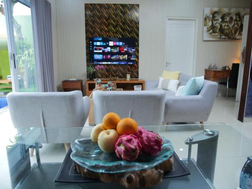 a glass table with a plate of fruit on it at iVilla in Jimbaran