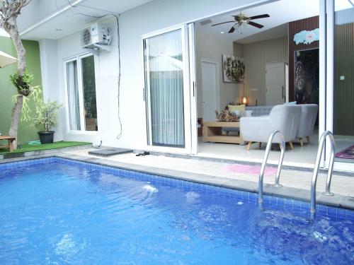 a swimming pool with a view of a living room at iVilla in Jimbaran