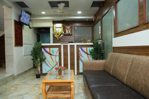 a living room with a couch and a table at Hotel Satyam Residency in Navi Mumbai