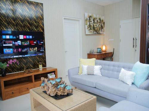 a living room with a blue couch and a tv at iVilla in Jimbaran