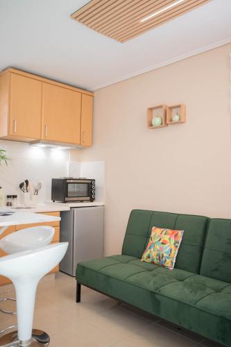 a living room with a green couch in a kitchen at Cozy Boutique in Vrahati