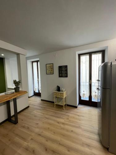 an empty living room with a refrigerator and wooden floors at I Bastioni Rooms in Peschiera del Garda