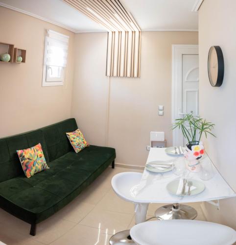 a living room with a green couch and a white table at Cozy Boutique in Vrahati