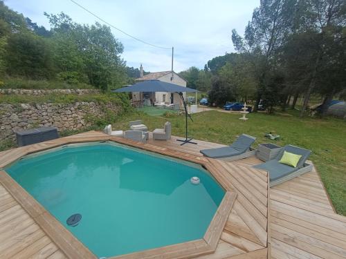 - une piscine avec une terrasse en bois et des chaises dans l'établissement Domaine des anges, à Tourves