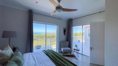 a bedroom with a bed and a ceiling fan at Pezula 's Paradise in the Sun - No Loadshedding in Knysna