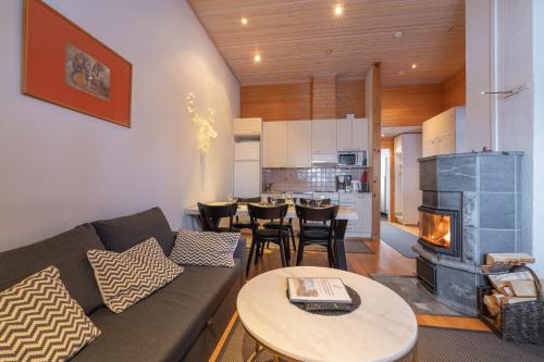 a living room with a couch and a fireplace at Kuukkeli Apartments Suite in Saariselka