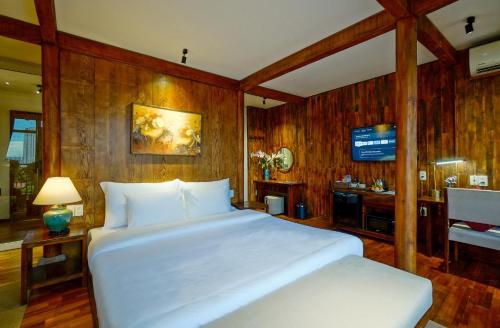 a bedroom with a large white bed and a desk at Nexus House Lang Bao Chi in Ho Chi Minh City