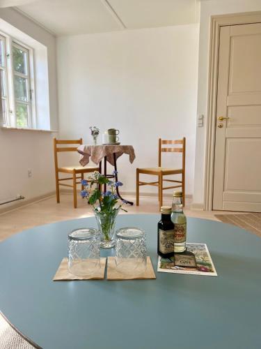 a room with a table with a vase of flowers at Noorbohandelens Bed & Breakfast in Stege