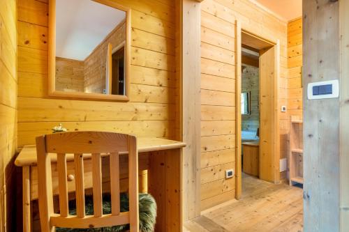 a wooden cabin with a wooden table and a wooden chair at Agritur El Casel in Brentonico