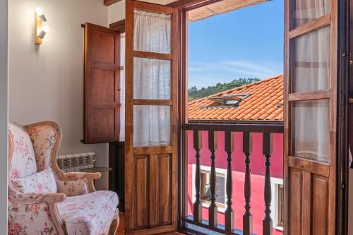 an open door to a balcony with two chairs at Apartamentos El Rincón de Bustio in Bustio