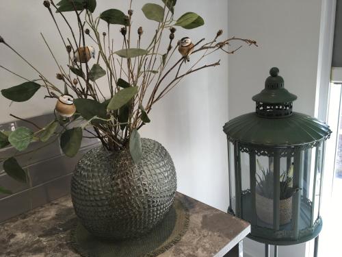 a vase with a plant in it next to a lamp at The Bungalow and Studio Apartments in Lytham St Annes